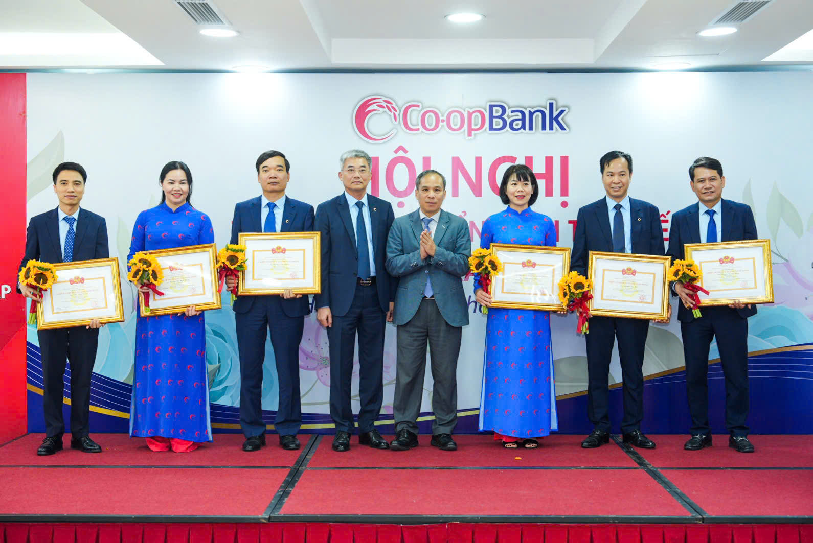 Đồng chí Đoàn Thái Sơn - Ủy viên Ban thường vụ Đảng ủy, Phó Thống đốc NHNN Việt Nam trao danh hiệu “Chiến sĩ thi đua ngành Ngân hàng” và đồng chí Nguyễn Quốc Cường - Bí thư Đảng bộ, Chủ tịch HĐQT Co-opBank tặng hoa cho các cá nhân thuộc Co-opBank